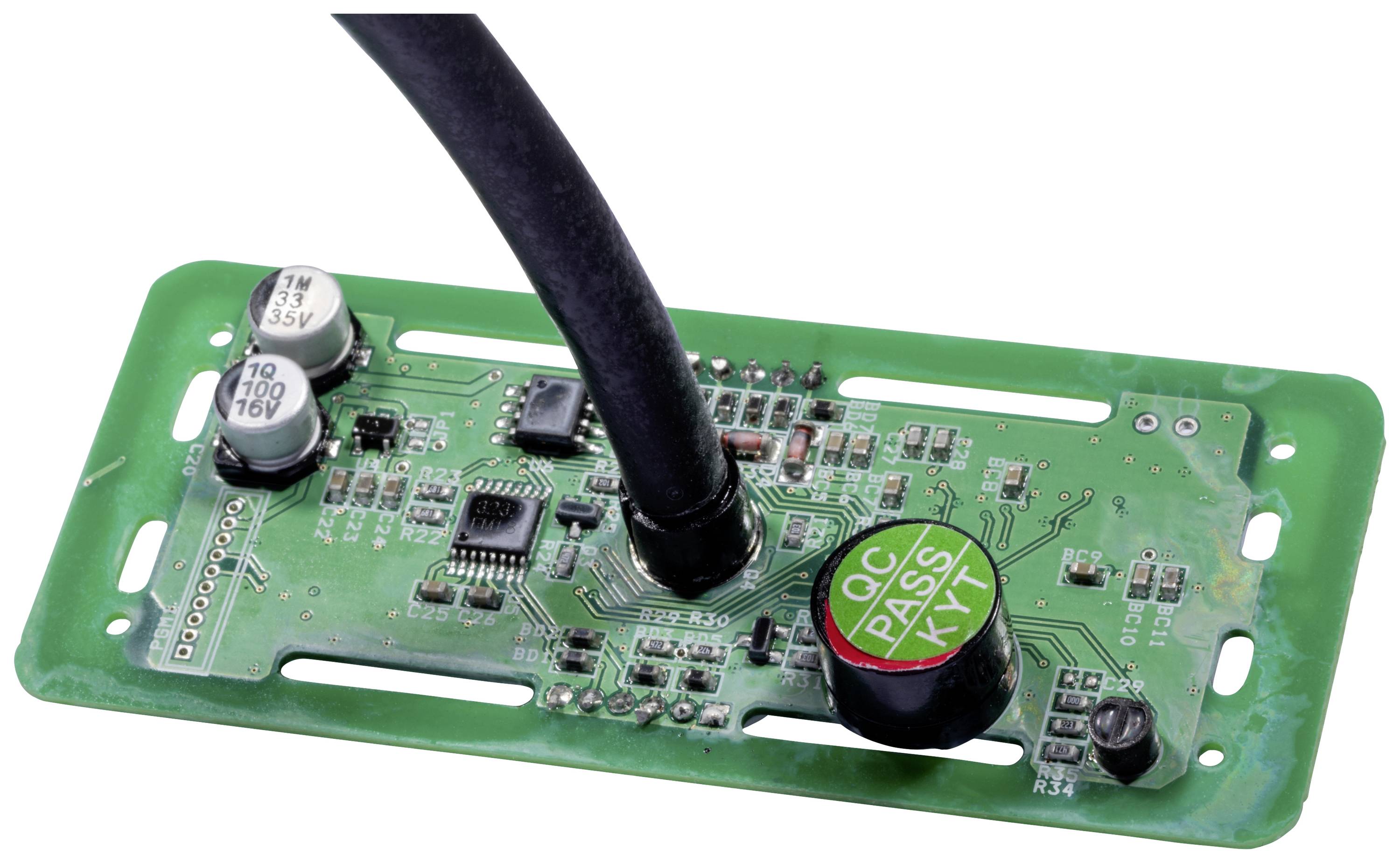 Circuit imprimé vert avec divers composants électroniques et un câble central connecté. Principalement des circuits et des condensateurs visibles.