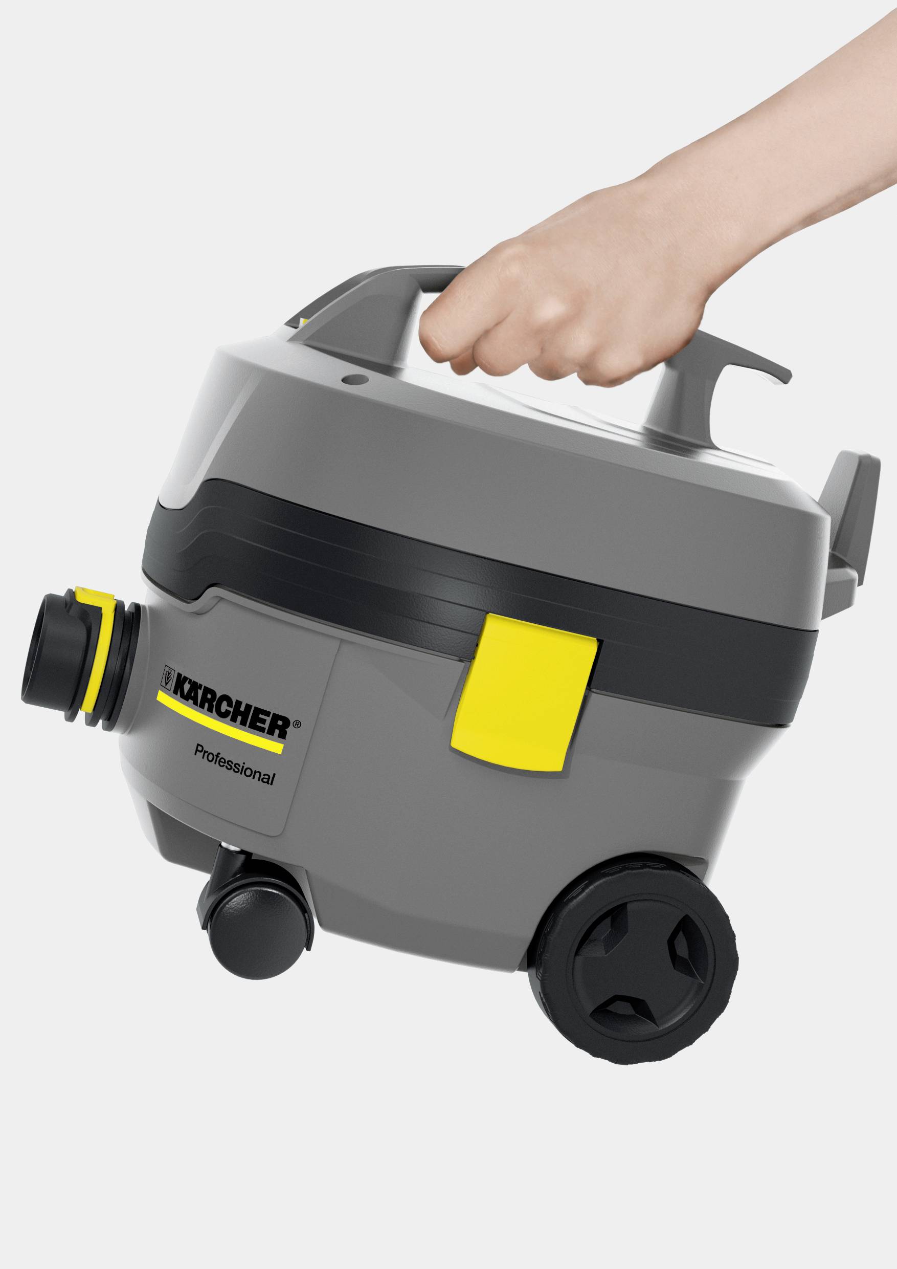 Une main tient un aspirateur industriel Kärcher gris et jaune avec des roues et une poignée de transport.