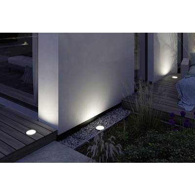 Terrasse moderne éclairée avec des luminaires encastrés au sol, créant une atmosphère chaleureuse et intimiste en soirée.