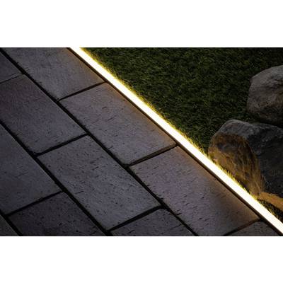 Pavés à côté d'un gazon synthétique vert, séparés par une fine bande lumineuse. Un grand galet se trouve à droite.