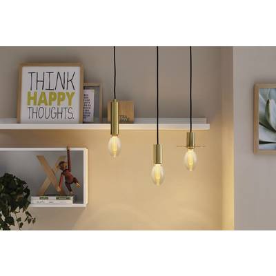 Trois ampoules suspendues illuminent une pièce avec une étagère. Sur l'étagère, un panneau est affiché avec l'inscription « Pensez à des pensées positives ».