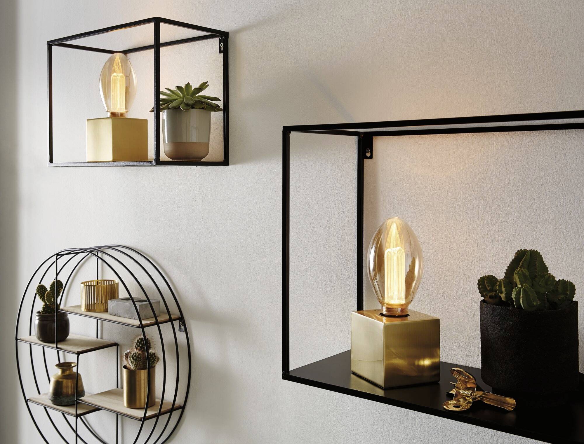 Étagères murales aux formes géométriques : une étagère rectangulaire avec une lampe et une plante, une étagère ronde avec des objets décoratifs.