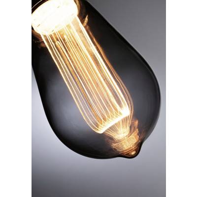 Ampoule à filament visible, émettant une lumière chaude, photographiée dans un environnement sombre.