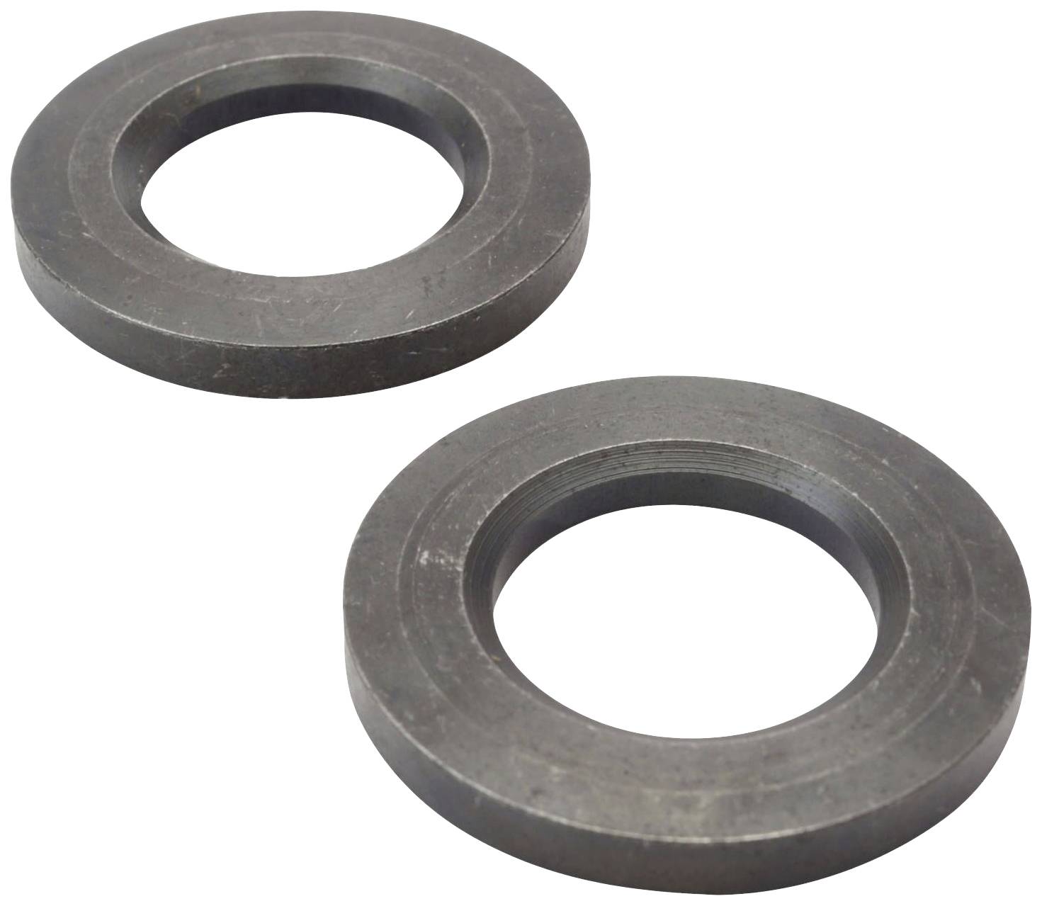 Deux anneaux métalliques sombres sont posés côte à côte sur une surface claire. Ils ont une forme ronde et une ouverture centrale.
