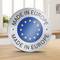 Emblème rond avec un anneau d'étoiles de l'UE sur fond bleu et l'inscription « MADE IN EUROPE ». L'arrière-plan montre une scène de cuisine floue.