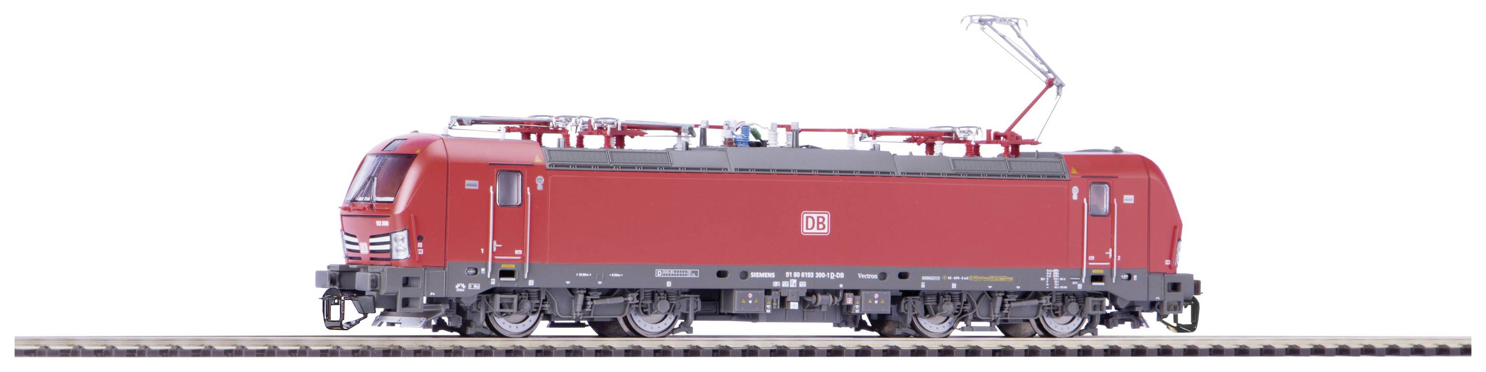 Modèle rouge d'une locomotive électrique sur une voie ferrée, photographié de côté, avec le pantographe dirigé vers le haut et bien visible.