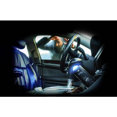 Une personne regarde à l'intérieur d'une voiture de l'extérieur, à travers la vitre latérale fermée. L'habitacle est vide, à l'exception d'un éthylotest posé sur le siège du conducteur.