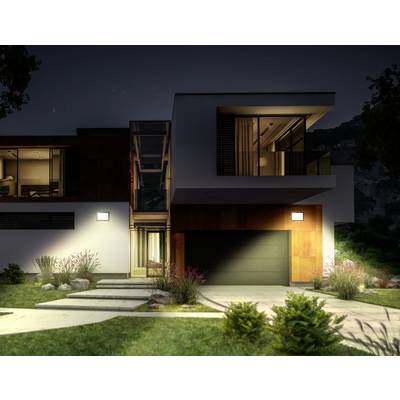 Maison moderne à deux étages la nuit, éclairée. Grandes fenêtres, chemin pavé, jardin bien entretenu au premier plan.
