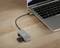 Un ordinateur portable est connecté via un hub USB-C avec plusieurs ports, dont un pour les cartes SD. Le dispositif est posé sur une table en bois.