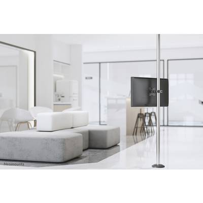 Un espace moderne et lumineux avec des meubles blancs et un canapé gris. À droite de l'image, un écran plat est posé sur un support haut.