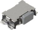 Une composante électronique de forme rectangulaire, probablement un capteur CMS ou un interrupteur, montée sur un circuit imprimé.