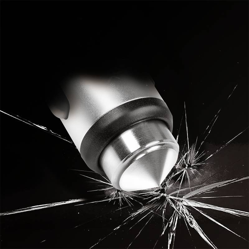 Un outil à pointe métallique brise une surface en verre. Gros plan de l'action sur un fond noir.