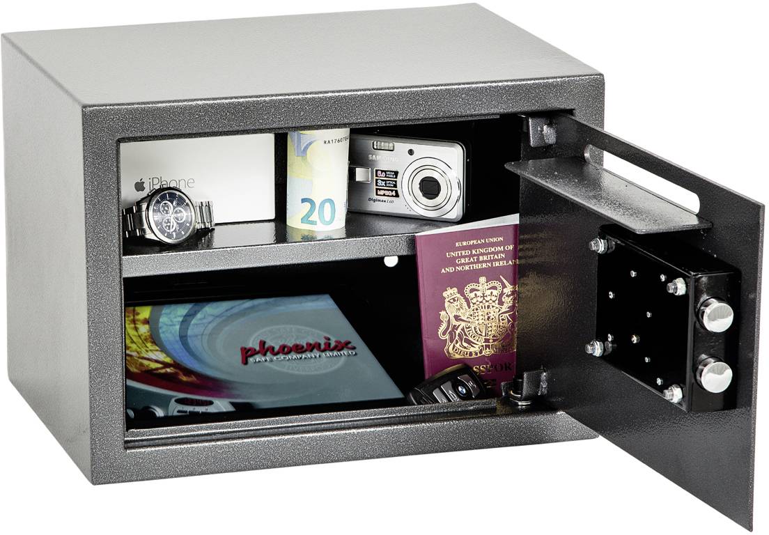 Un coffre-fort ouvert expose une montre, un billet de banque, un appareil photo, un emballage de smartphone et des passeports qui y sont conservés.