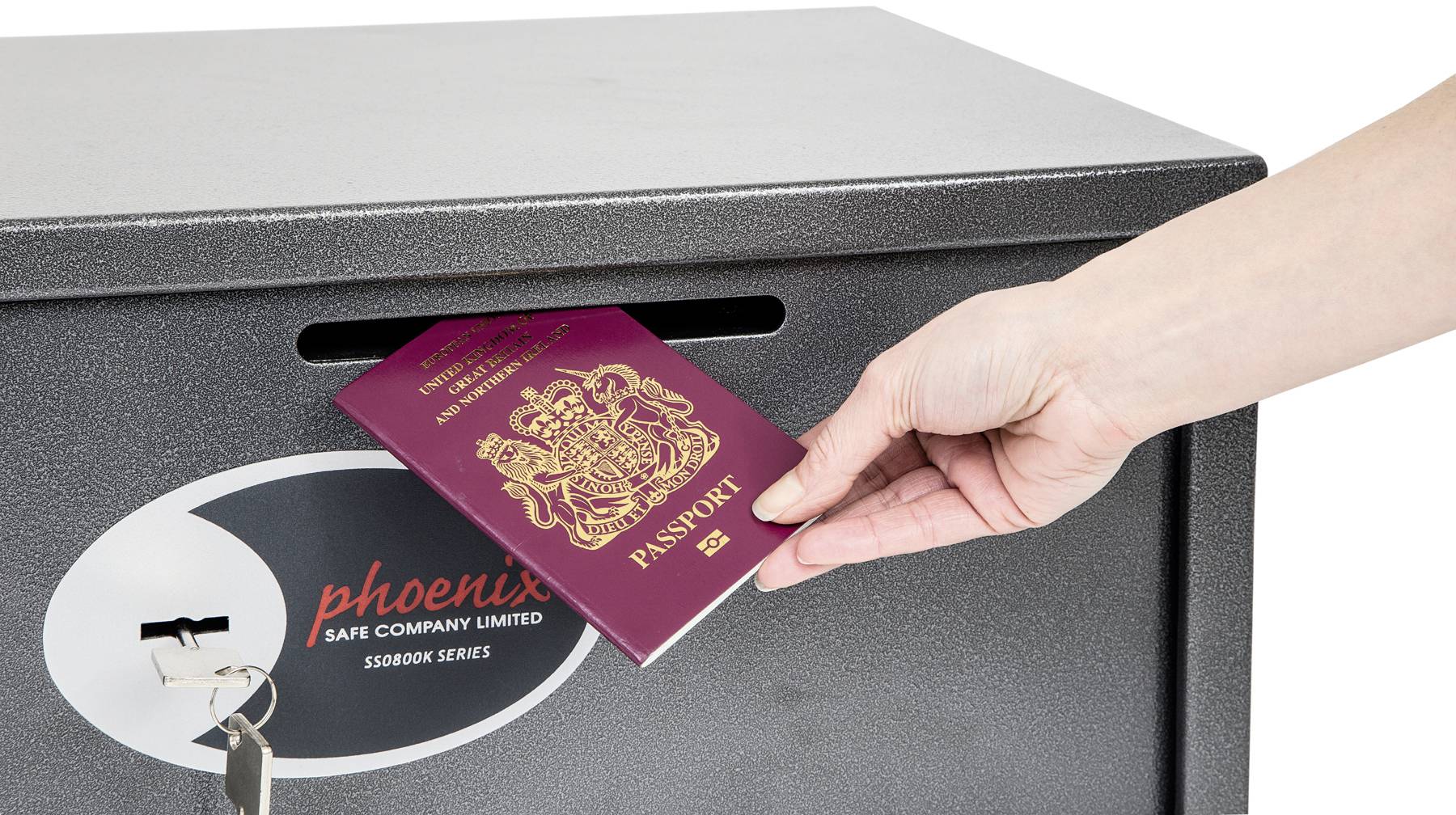 Une main dépose un passeport rouge foncé dans un coffre-fort avec une fente d'insertion. Une clé est insérée dans la serrure du coffre-fort.