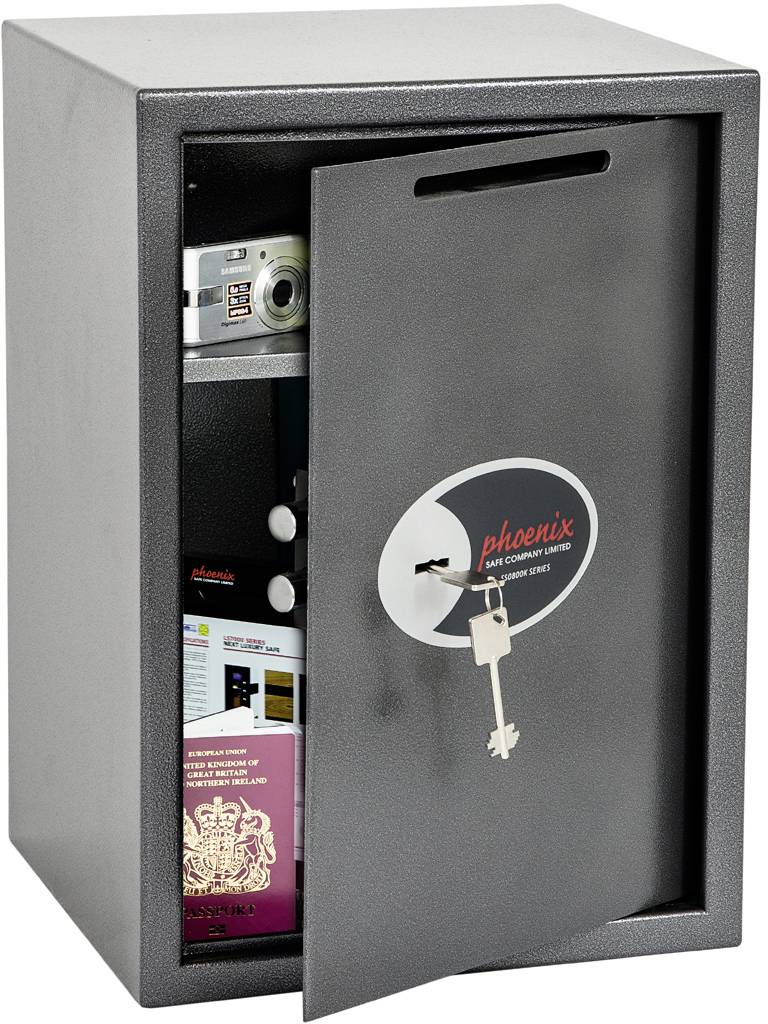 Un coffre-fort ouvert montre une caméra, des documents et un passeport. Une clé est suspendue à la serrure.