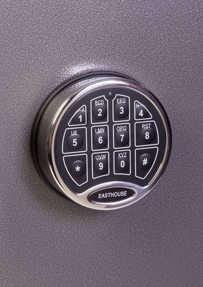 Un cadenas électronique à touches numériques de 0 à 9, fixé sur une surface métallique grise.