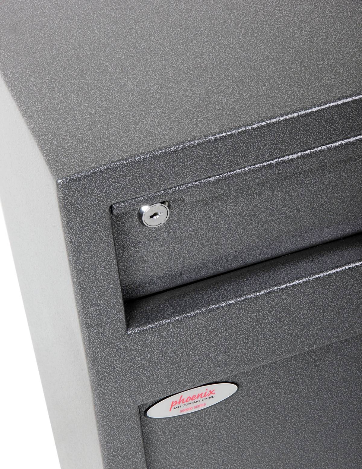 L'image montre une armoire de bureau grise avec un petit verrou sur le tiroir supérieur. Un écriteau du fabricant est placé sur l'armoire.