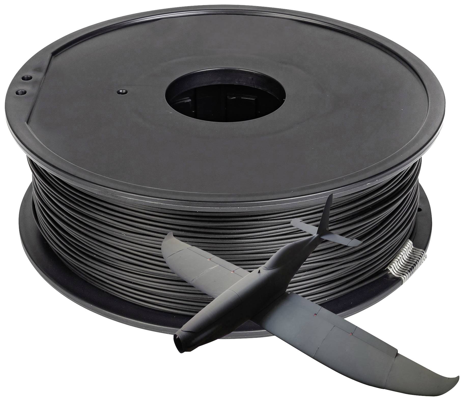 Bobine de filament avec un petit modèle d'avion en plastique ; représente l'utilisation de l'impression 3D dans la modélisation.