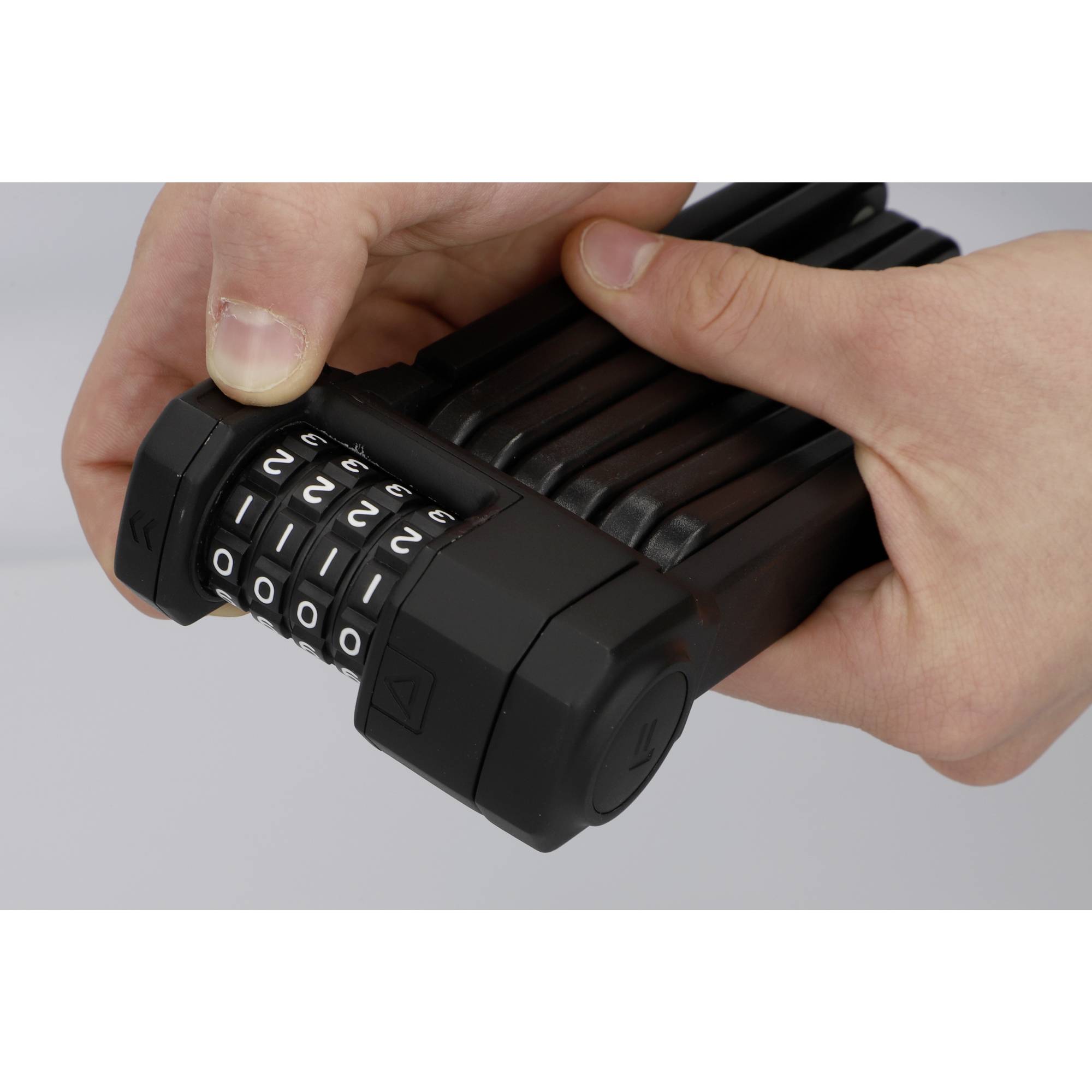 Une personne tient un cadenas à combinaison déjà réglée, prête à sécuriser un objet ou un vélo.