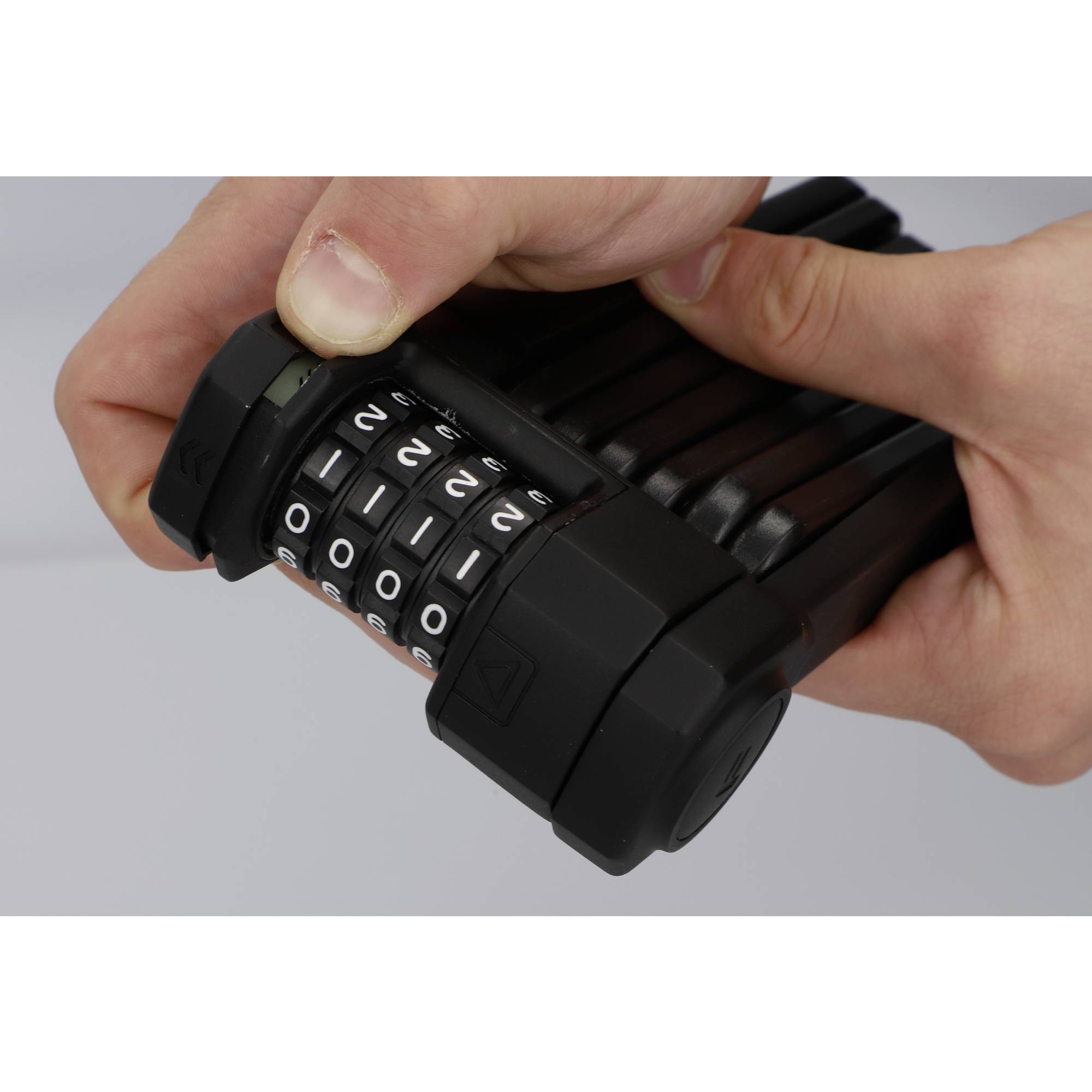 Deux mains tiennent un cadenas à code et règlent le code. Le cadenas est composé de segments noirs avec des chiffres blancs.