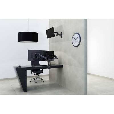 Bureau moderne avec un bureau sombre, deux écrans, une chaise noire et une lampadaire. L'horloge au mur indique 10h10.