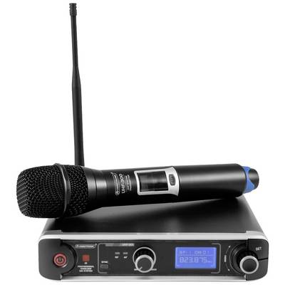 Le microphone est posé sur un récepteur sans fil équipé d'une antenne. Le récepteur affiche un écran numérique avec des informations sur le canal.