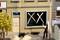Un modèle miniature montre un laveur de vitres devant un bâtiment dont les fenêtres sont marquées de croix noires. Un panneau sur la porte indique des travaux de rénovation.