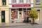 Une maquette miniature d'une boutique de chaussures portant l'inscription « Ma Chausserie ». Une personne accompagnée d'un enfant observe la vitrine.