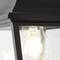 Une ampoule dans un luminaire noir et métallique. L'ampoule est allumée et dégage une lumière chaleureuse.