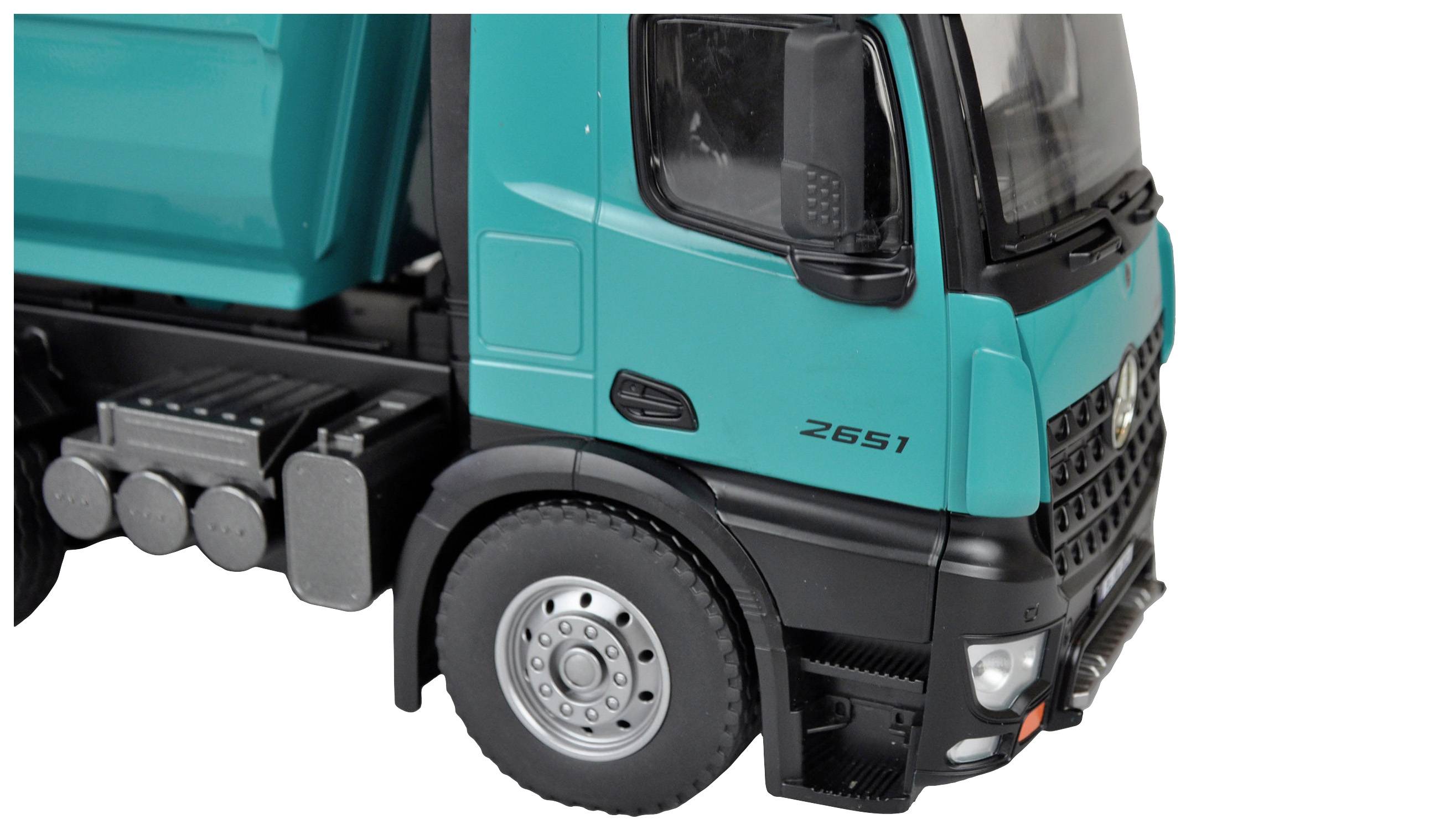 Un camion vert vu de côté, avec un focus sur la cabine du conducteur et la roue avant.