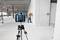 Un ouvrier utilise un télémètre laser pour mesurer des distances dans un bâtiment en construction, avec un appareil sur un trépied au premier plan.