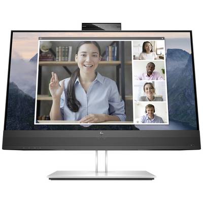 Un écran d'ordinateur portable affiche une réunion en visioconférence avec cinq personnes souriantes qui regardent la caméra. Des étagères à livres sont visibles en arrière-plan.
