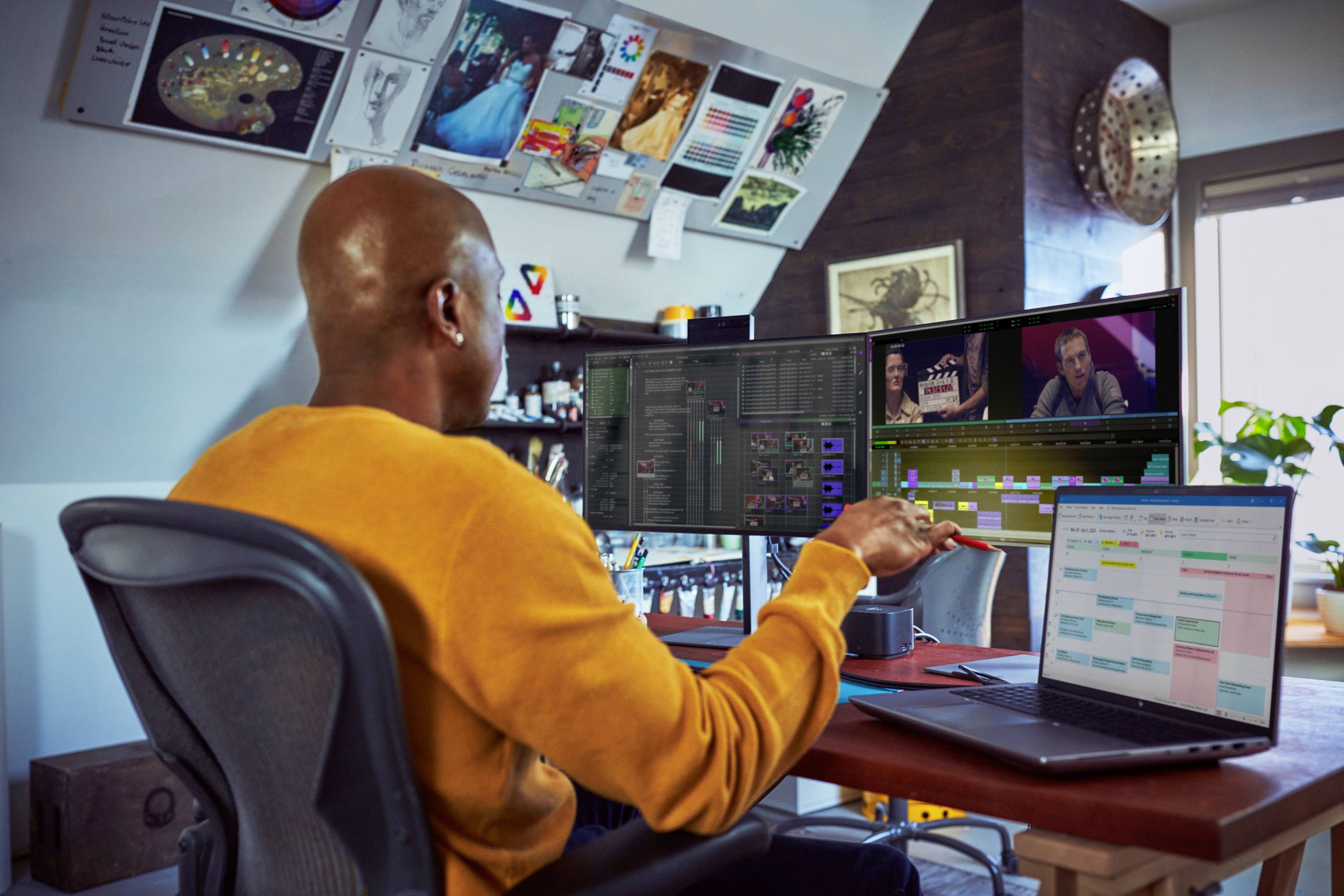 Une personne édite des vidéos sur deux écrans dans un bureau moderne. Sur l'ordinateur portable, on peut voir des diagrammes colorés.