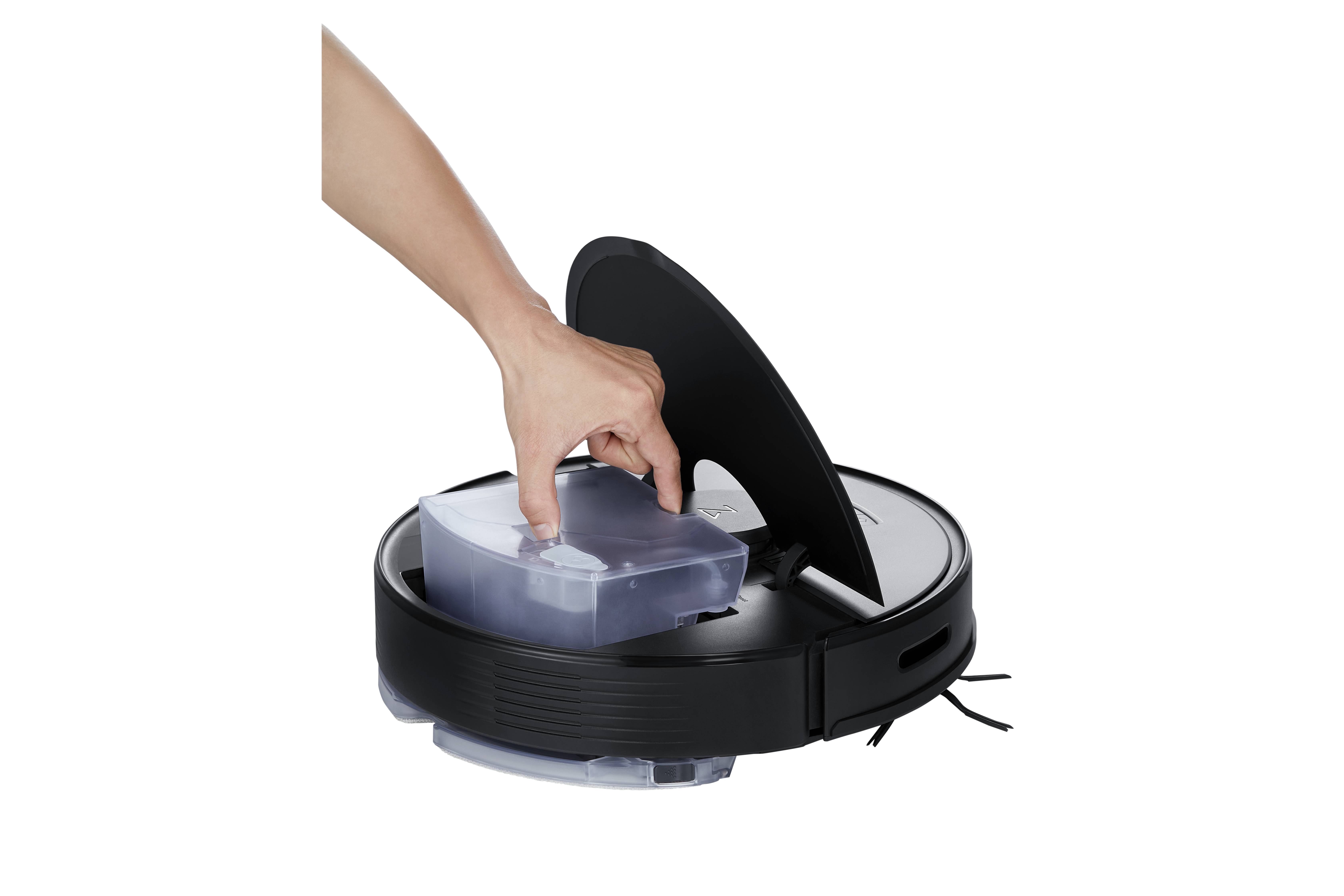 Une main soulève le réservoir à poussière d'un aspirateur robot circulaire pour le vider.