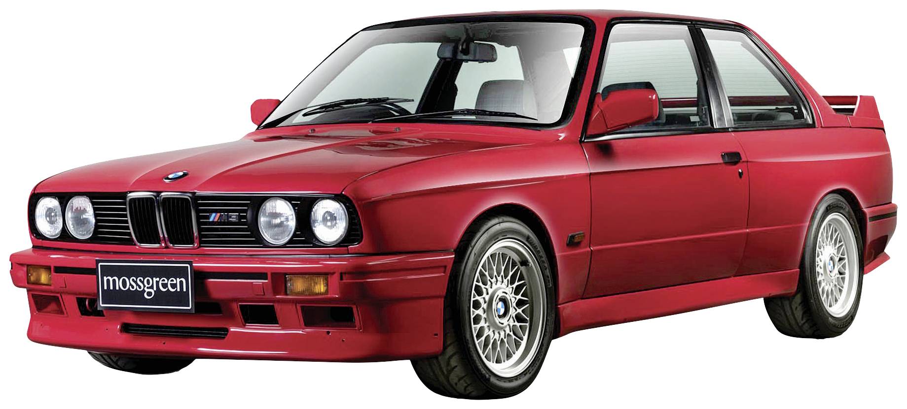 Une voiture rouge classique, probablement un ancien modèle BMW, photographiée de profil, révélant un design sportif et des jantes à rayons.
