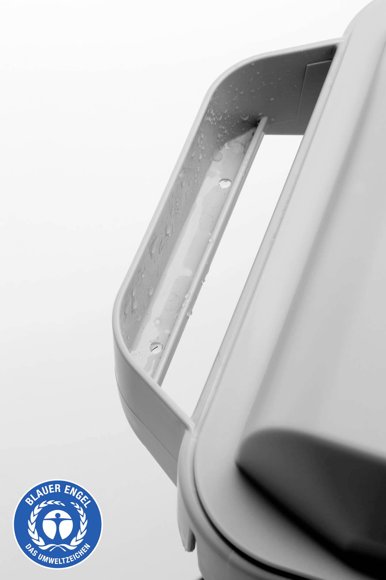 Le gros plan montre un seau gris avec une poignée de transport, portant l'éco-label 'Ange Bleu'. L'accent est mis sur le symbole de recyclage.