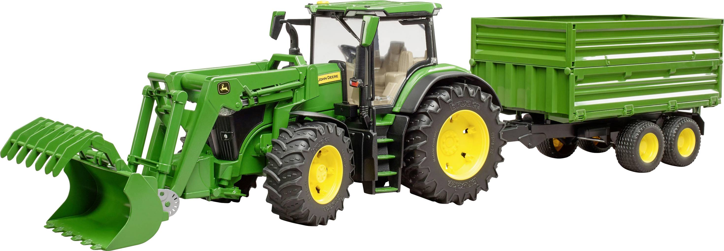 Un tracteur jouet vert avec chargeur frontal et remorque sur des roues jaunes. Le tracteur est posé sur une surface plane.