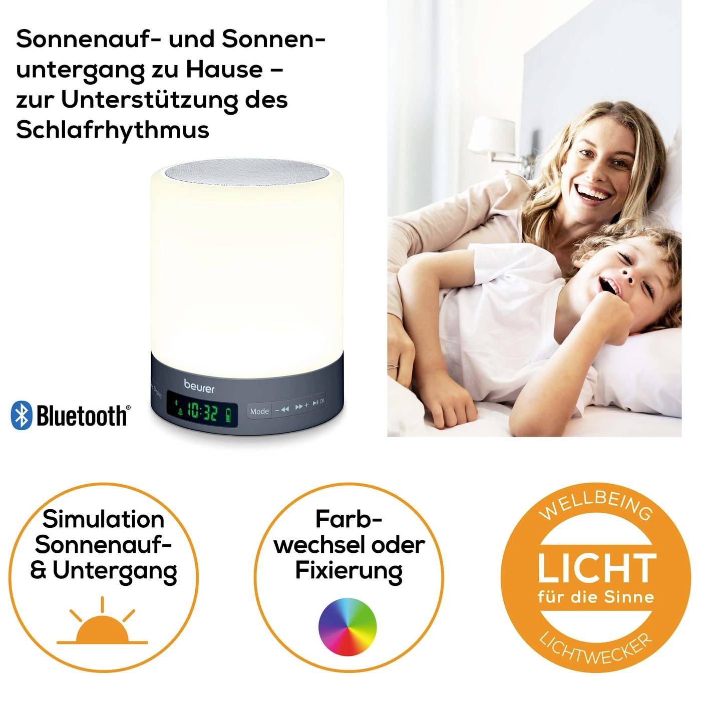 Réveil lumineux sur la table de chevet avec une mère souriante et son enfant dans le lit ; utilisé pour soutenir le rythme de sommeil par simulation lumineuse.
