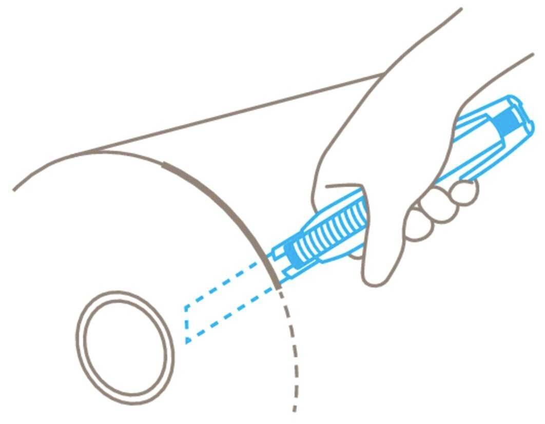 Une main tient un cutter et coupe une forme circulaire dans un rouleau de papier.