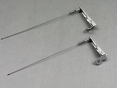 Deux brochettes métalliques avec supports sur un fond gris. Adaptées pour griller uniformément de la viande ou des légumes sur un barbecue.
