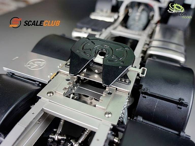 Gros plan d'un châssis de camion miniature avec une construction d'essieu et de suspension détaillée. Les logos 'SCALECLUB' et 'icon models' sont visibles.
