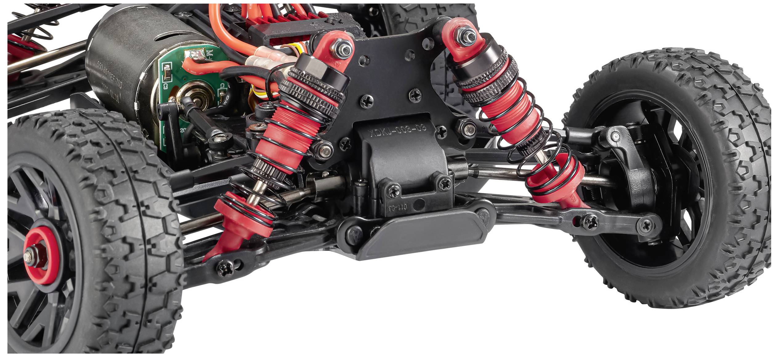 Une voiture télécommandée vue de très près montre la suspension et les amortisseurs en rouge et noir, adaptés au terrain.