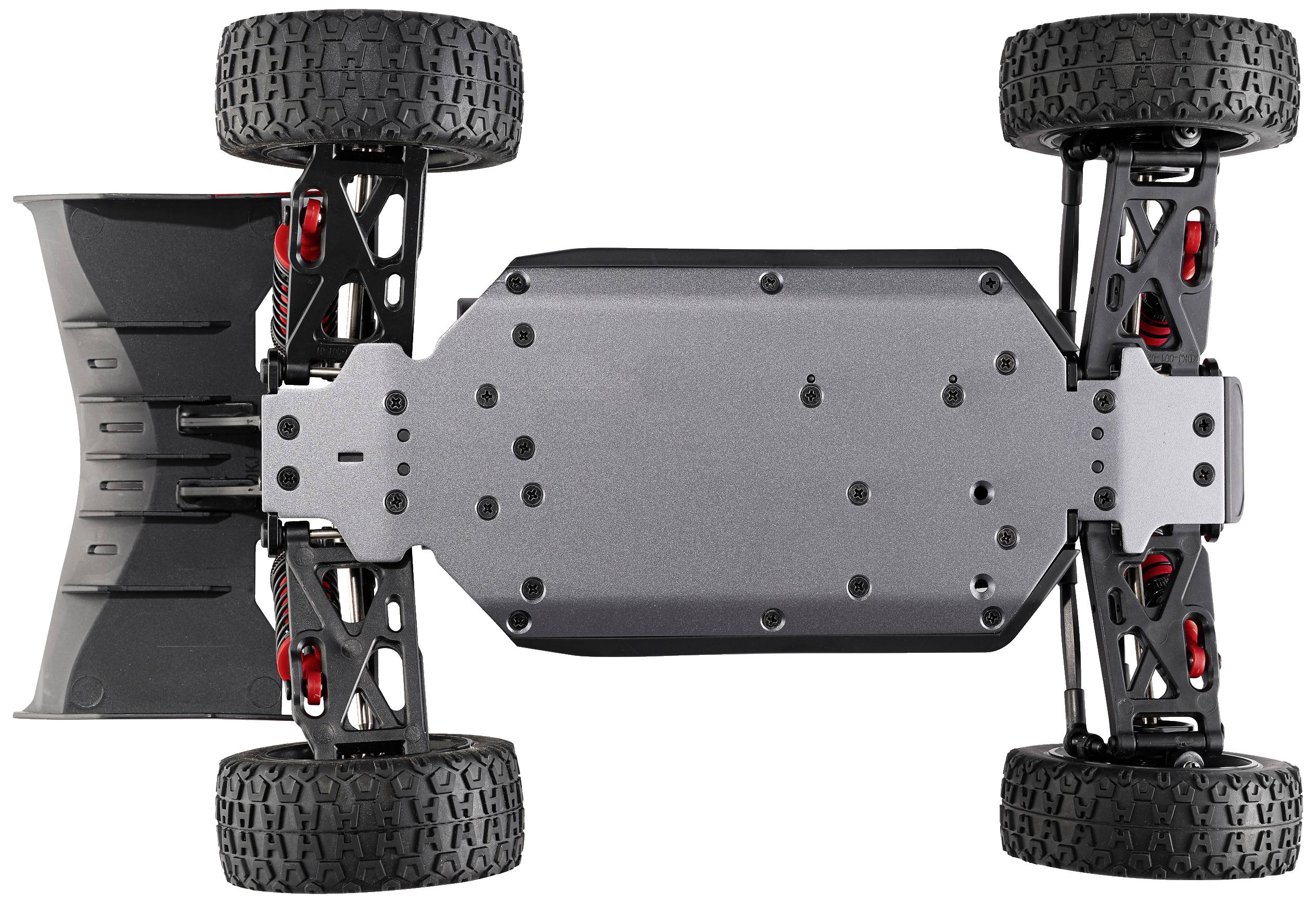 Dessous d'une voiture télécommandée ; plaque de châssis noire, pneus tout-terrain robustes, amortisseurs et triangles de suspension visibles.