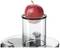 Une pomme rouge est placée dans un cylindre en verre, prête à être pressée. La pomme est fraîche et brillante.