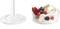 Un pot en verre rempli de crème, garni de groseilles rouges, de myrtilles, de framboises, de mûres et d'éclats d'amandes.