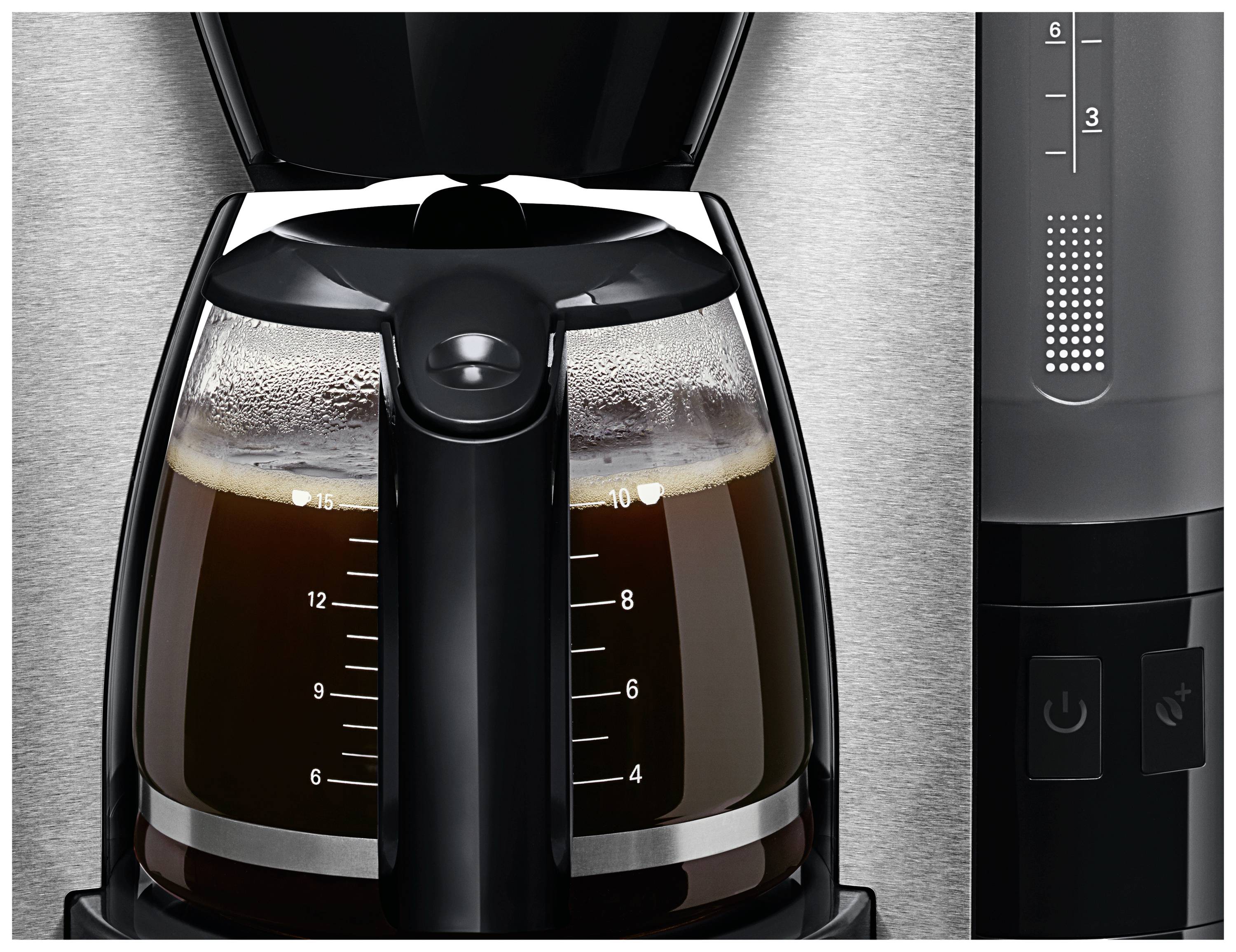 Une machine à café en acier inoxydable avec du café frais dans la carafe en verre. Des indicateurs de niveau sont visibles à gauche.