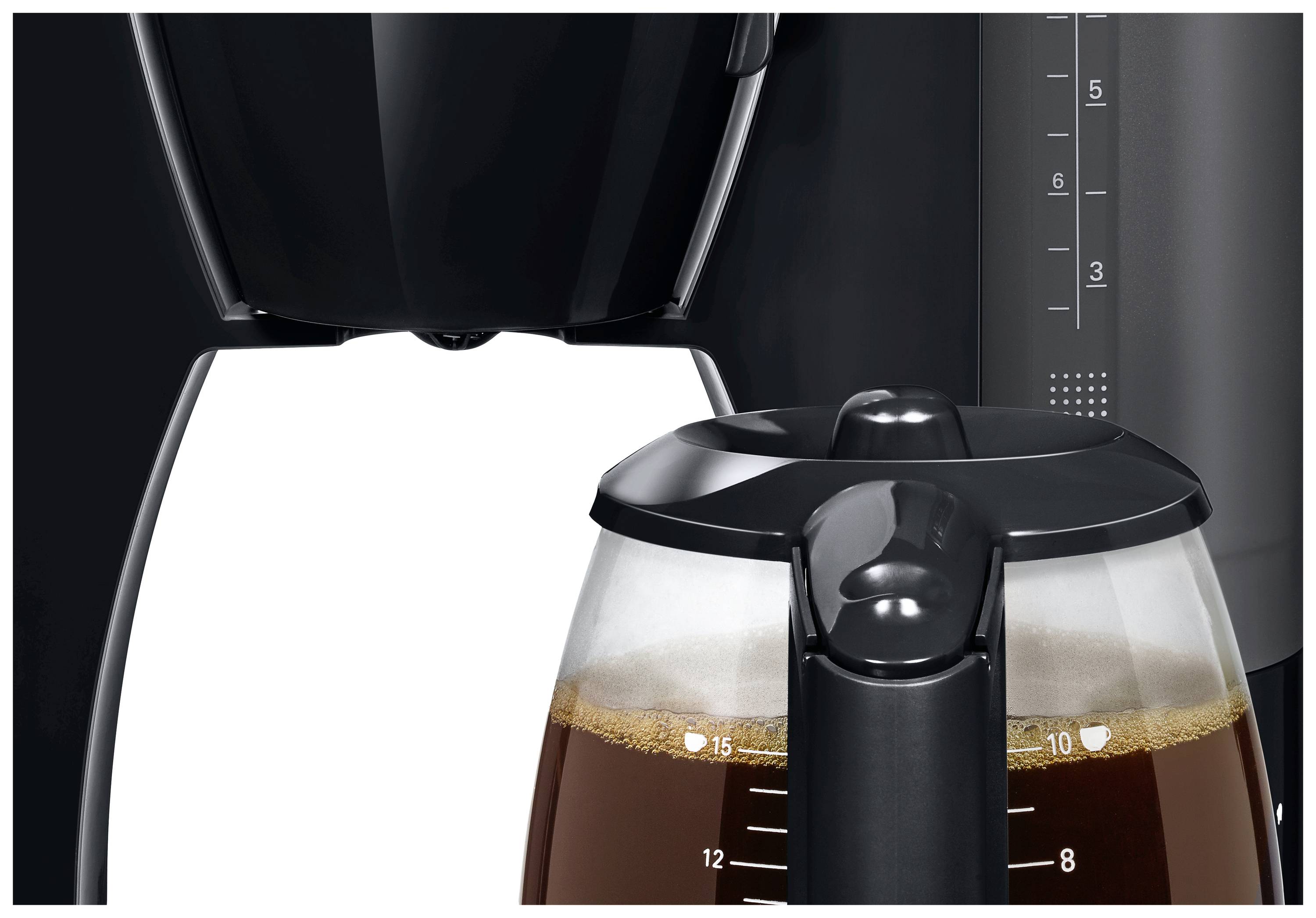 Une machine à café noire avec une carafe en verre, à moitié remplie de café infusé. La carafe est positionnée sous le porte-filtre.