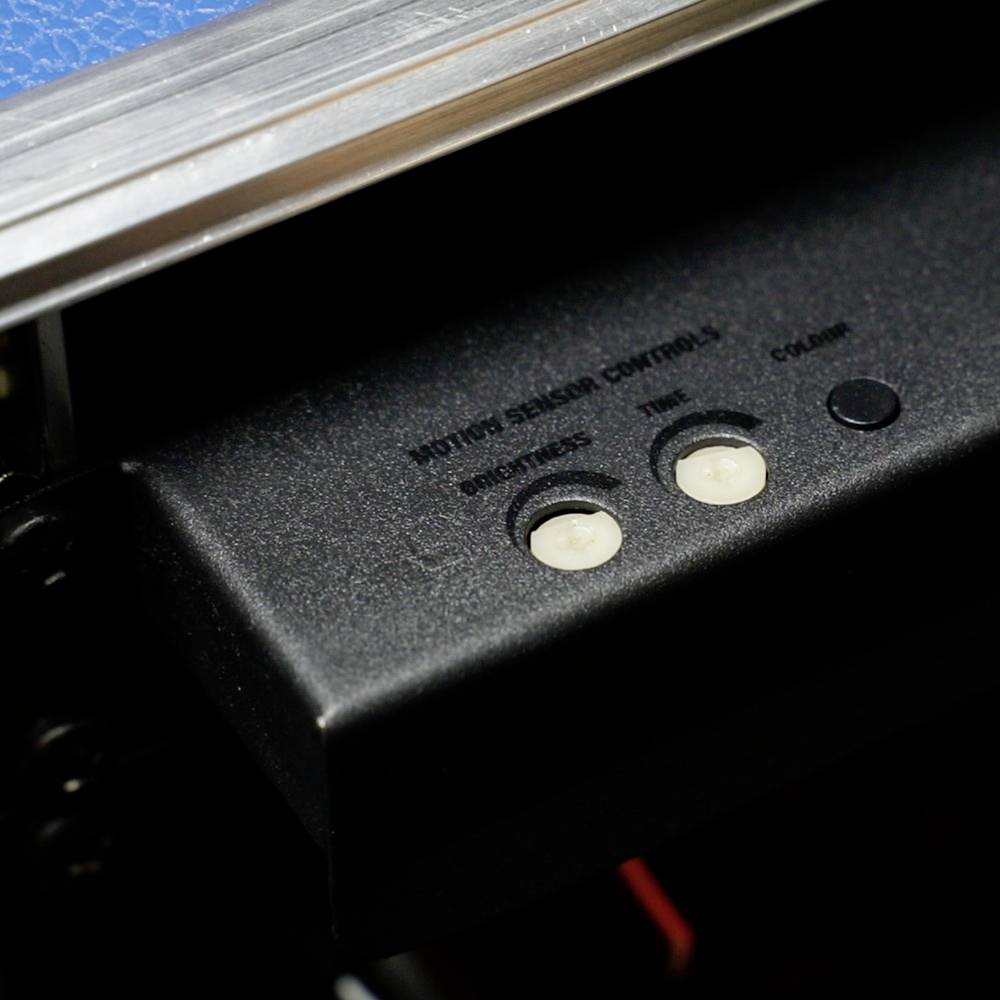 Gros plan d'un panneau de contrôle avec les étiquettes 'Commandes de réglage de l'image', 'Teinte' et 'Couleur'. Montre deux boutons blancs et un bouton noir.