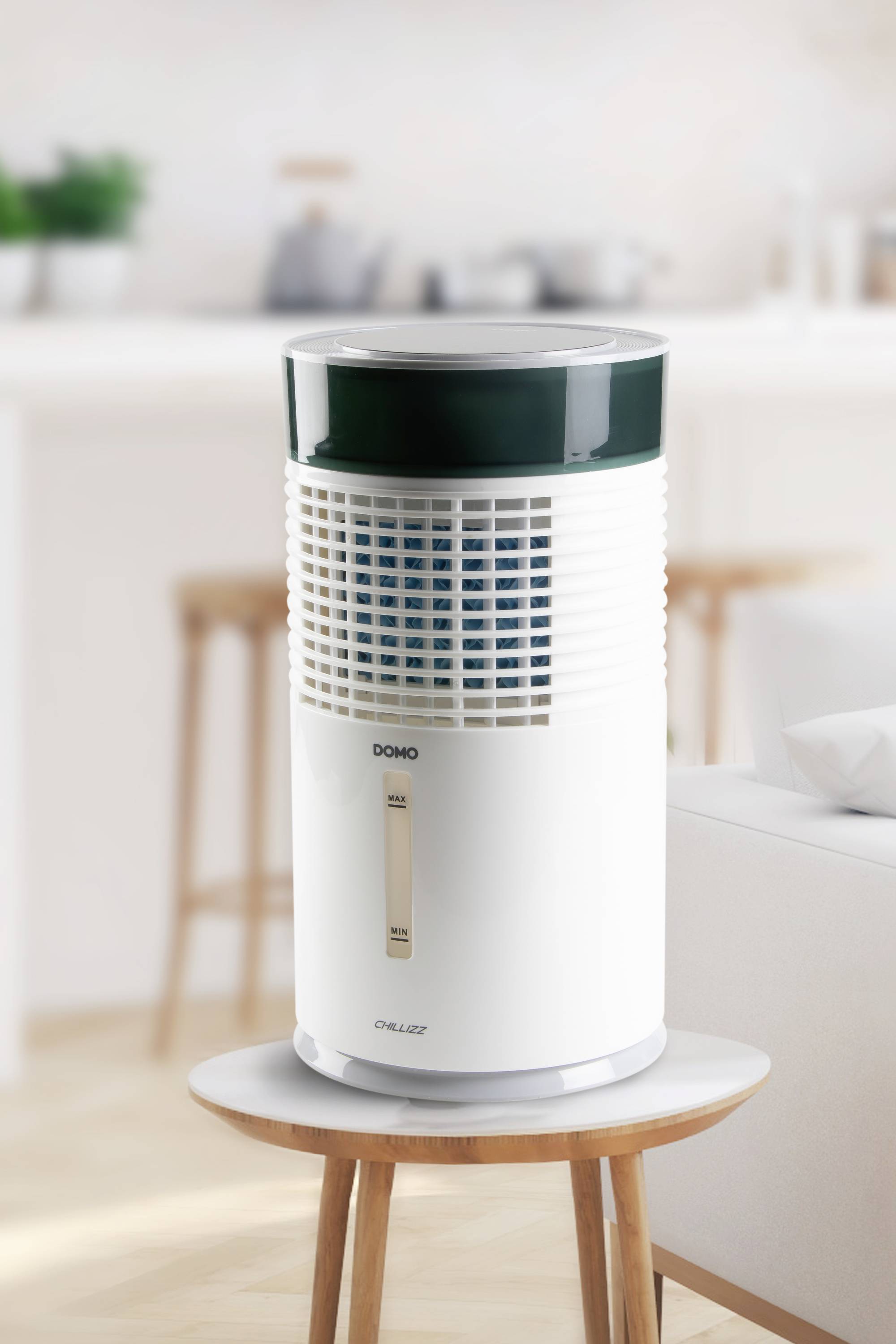 Purificateur d'air posé sur une table dans un salon au design moderne. Des ustensiles de cuisine flous sont visibles en arrière-plan.