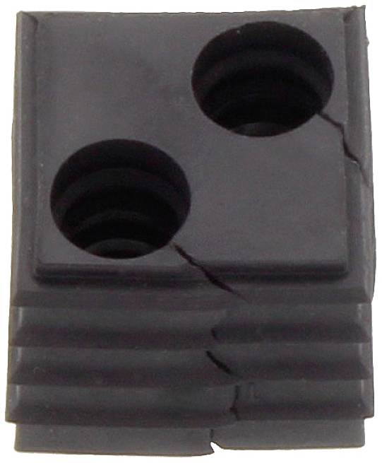 Un morceau de plastique gris rectangulaire avec deux trous ronds et plusieurs fissures sur sa surface.